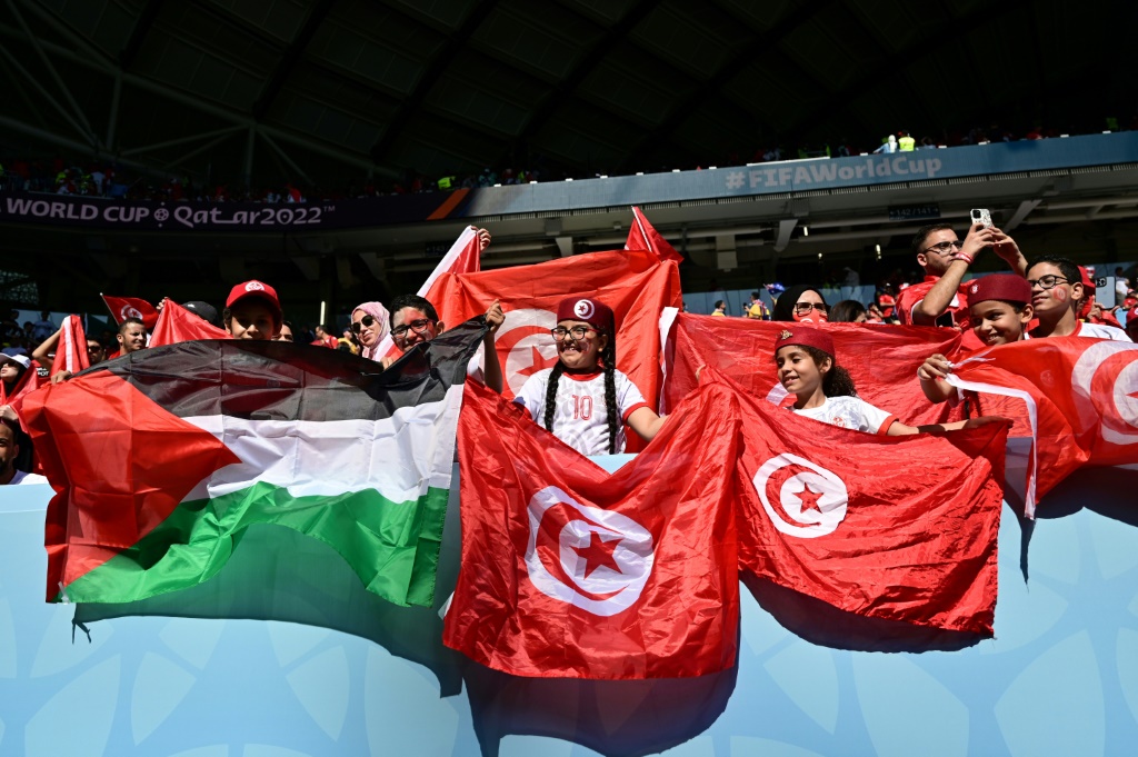Des supporters agitent les drapeaux palestinien et tunisien, avant le match Tunisie-Australie, le 26 novembre 2022 lors de la Coupe du monde de football à Doha, au Qatar