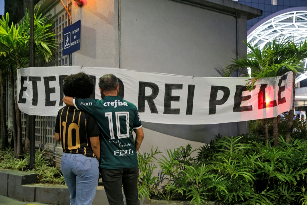 Des fans de Pelé devant une bannière sur laquelle on peut lire "Eternal King Pele" à l'extérieur de l'hôpital Albert Einstein