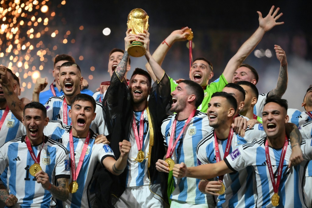 Lionel Messi brandit la Coupe du monde au milieu de ses coéquipiers de l'Argentine championne du monde le 18 décembre 2022 à Doha