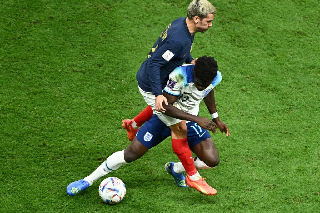 L'attaquant français Antoine Griezmann au duel avec l'attaquant anglais Bukayo Saka pendant le quart de finale de la Coupe du monde 2022 entre l'Angleterre et la France