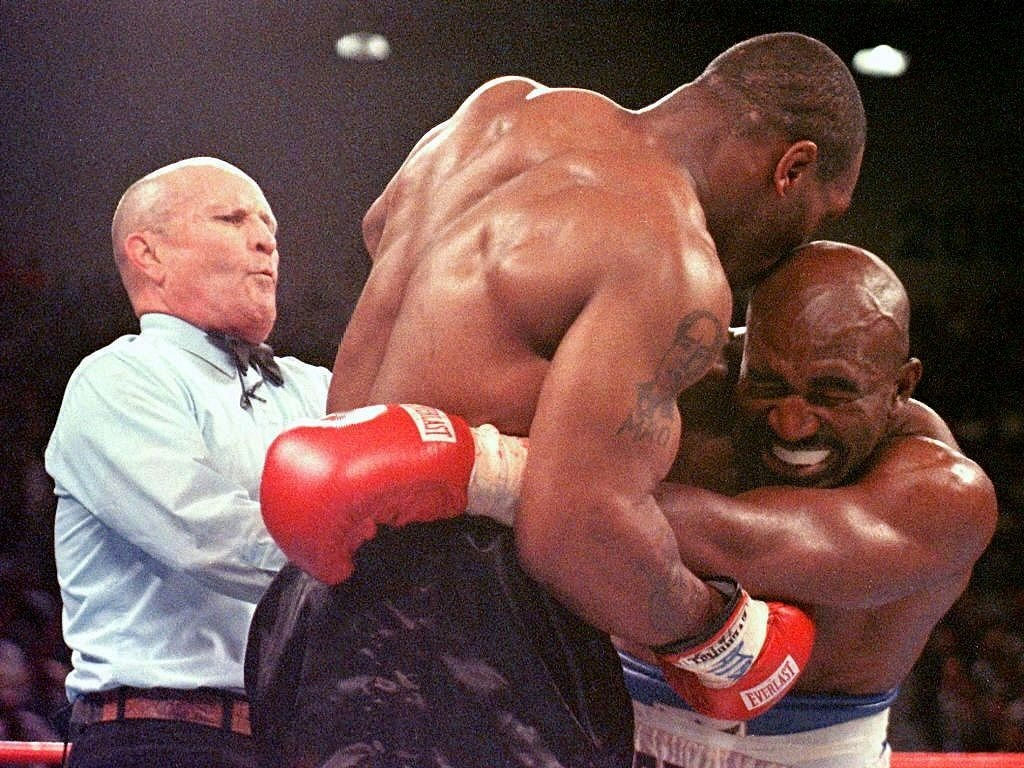 L'arbitre Mills Lane (à gauche) pendant le match entre Mike Tyson (centre) et Evander Holyfield le 28 juin 1997 à Las Vegas