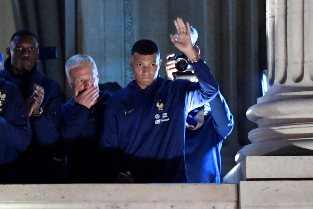 L'attaquant de l'équipe de France Kylian Mbappé salue la foule au balcon de l'Hôtel Crillon