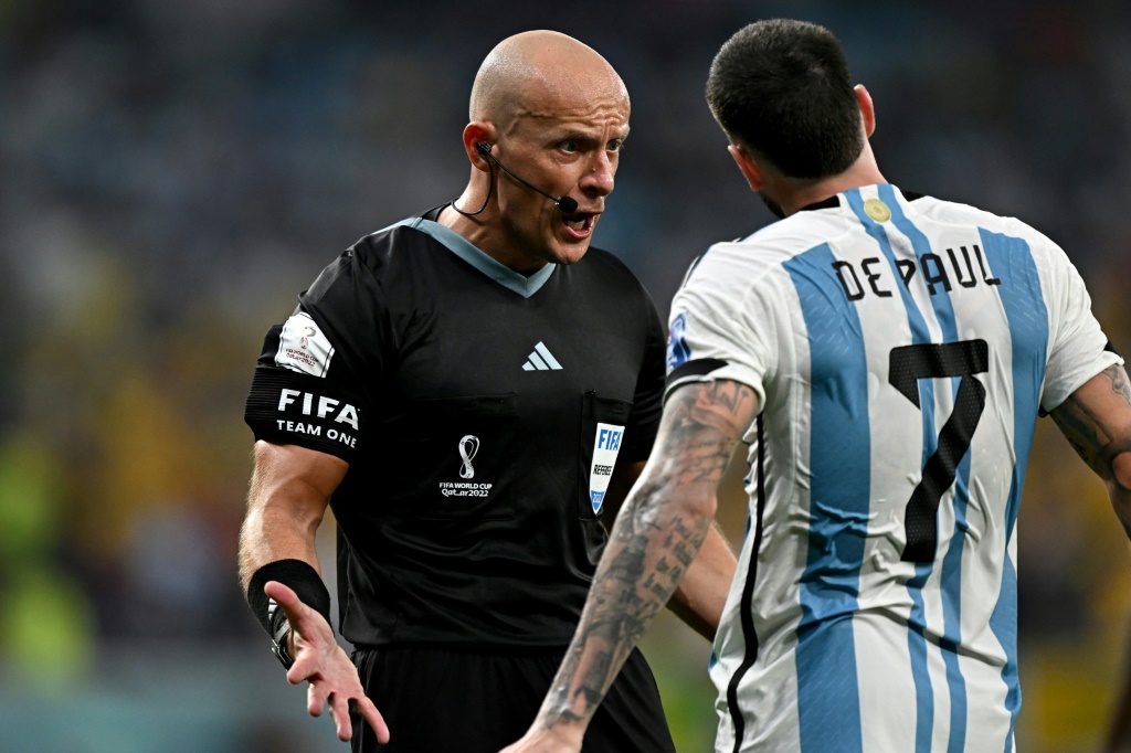 L'arbitre polonais Szymon Marciniak réprimande le milieu argentin Rodrigo De Paul lors d'un match du Mondial