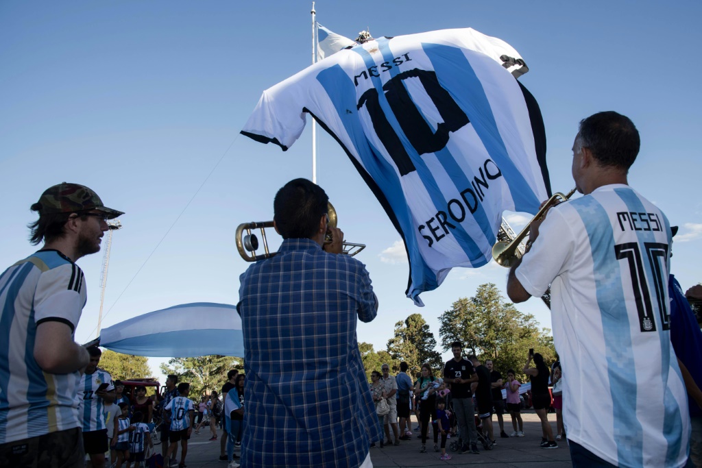 Des supporters de l'Argentine devant un maillot géant de la vedette de l'Albiceleste Lionel Messi