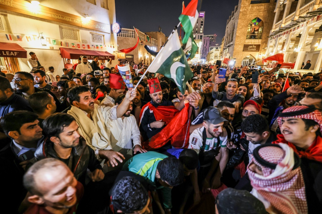 Des supporters marocains célèbrent après la victoire de leur pays face au Portugal en Coupe du monde au Souq Waqif à Doha