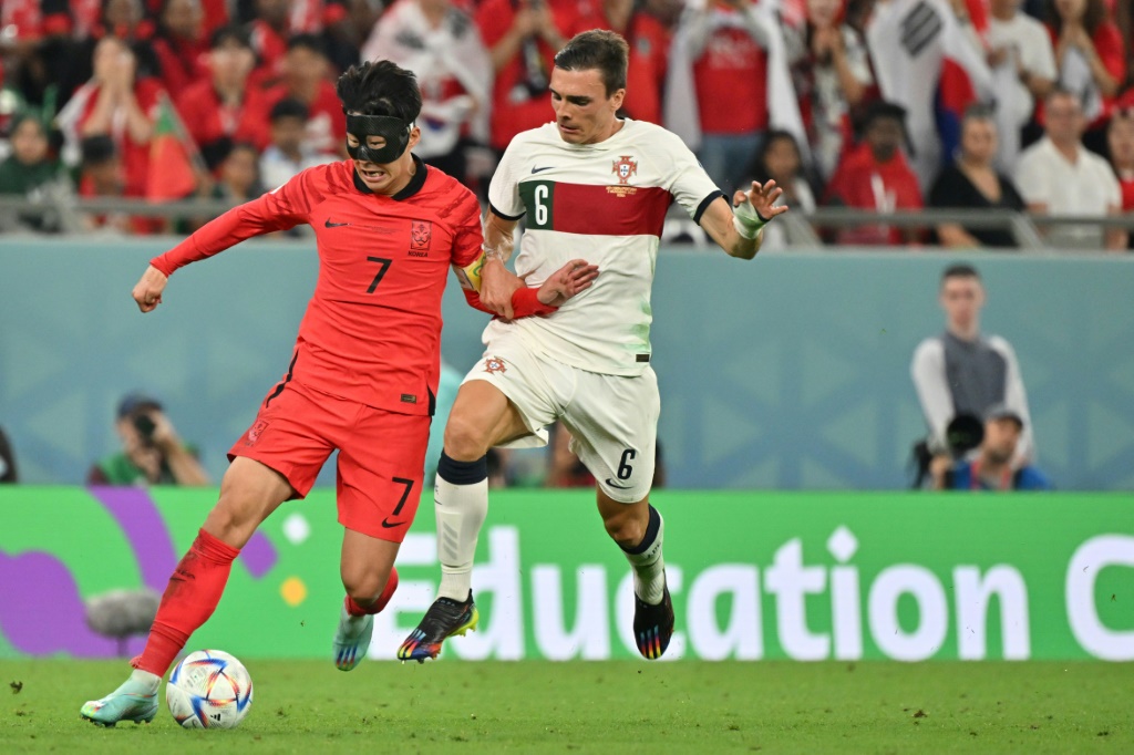 Le Sud-Coréen Son Heung-min (G) à la lutte avec le Portugais Joao Palhinha lors du match du Mondial entre la Corée du Sud et le Portugal le 2 décembre 2022 à Doha