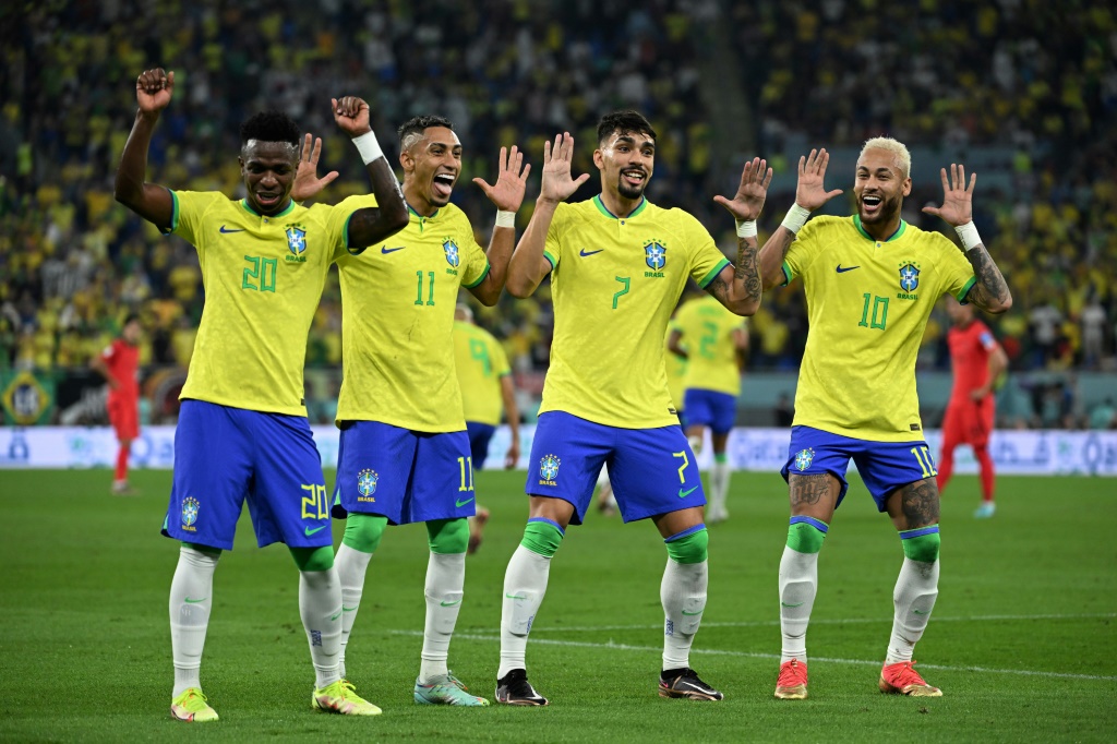 Les Brésiliens Vinicius Junior, Raphinha, Lucas Paqueta et Neymar (de g. à d.) après que ce dernier a marqué le deuxième but de son équipe sur pénalty lors du huitième de finale du Mondial 2022 entre le Brésil et la Corée du Sud au stade 974 à Doha, le 5 décembre 2022