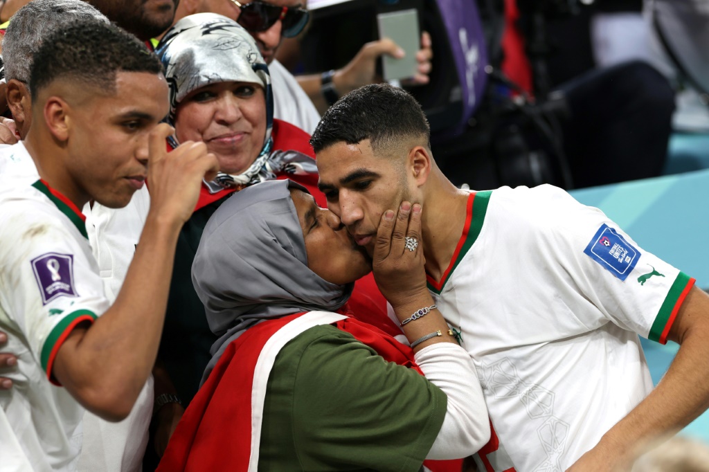 Le défenseur du Maroc Achraf Hakimi (D) célèbre avec ses proches avec la victoire contre la Belgique, lors du Mondial, le 27 novembre 2022 à Doha