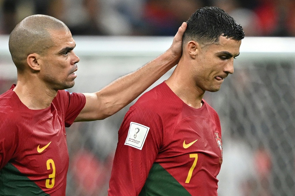 Le numéro 7 portugais Cristiano Ronaldo(dr) réconforté par le numéro 3 Pepe lors du match contre la Suisse (6-1) de 1/8 de finale du Mondial au Qatar, le 6 décembre 2022.