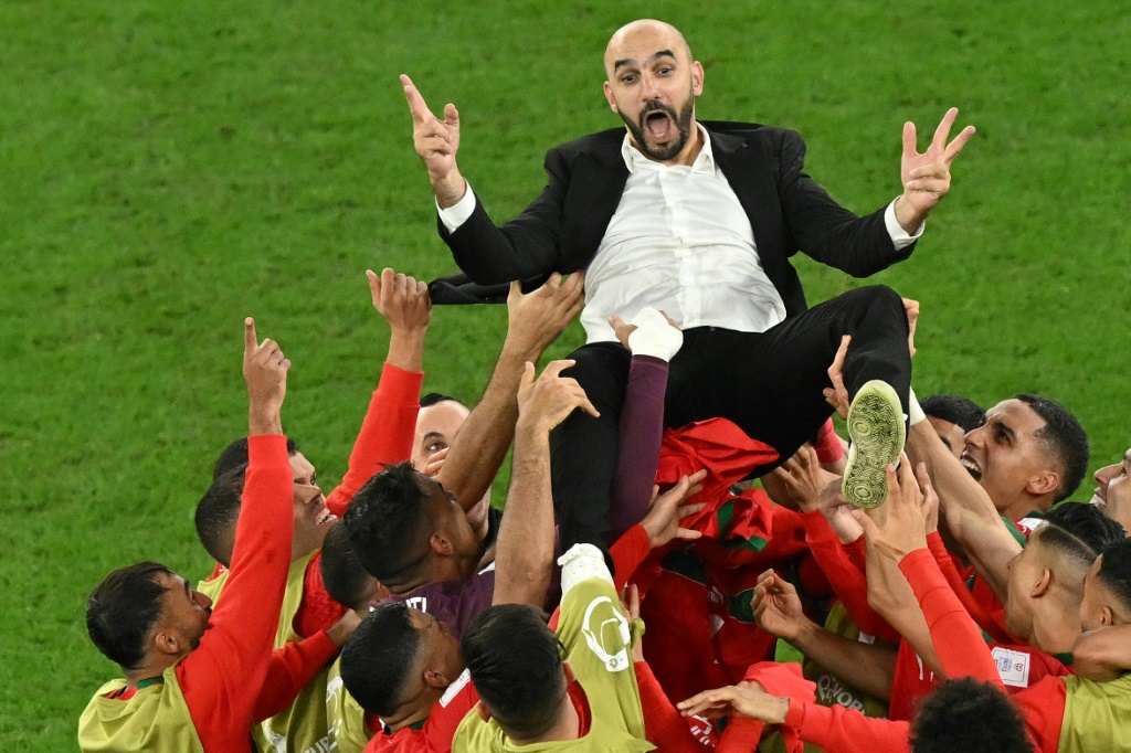 Le sélectionneur du Maroc Walid Regragui porté en triomphe par ses joueurs après la qualification face à l'Espagne, le 6 décembre 2022 à Doha