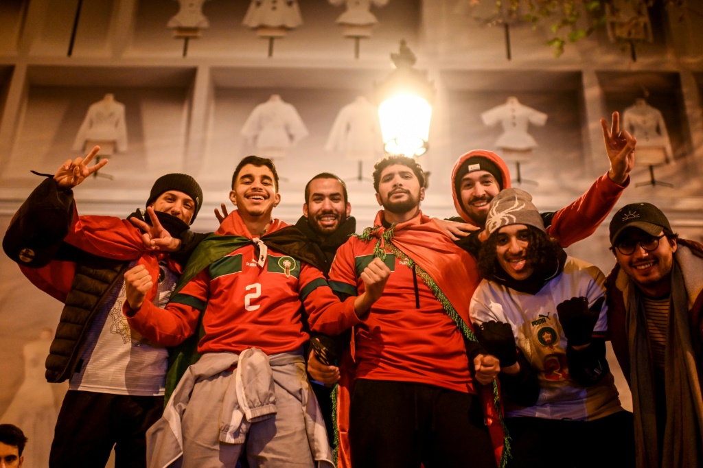 Des supporters célèbrent la victoire du Maroc en quart de finale de la Coupe du monde au Qatar face au Portugal sur les Champs-Élysées à Paris, le 10 décembre 2022