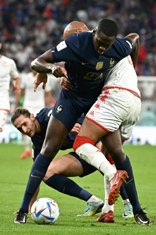 Ibrahima Konate et Adrien Rabiot de l'équipe de France à la lutte avec le Tunisien Issam Jebali au Mondial de foot, le 30 novembre 2022 à Doha