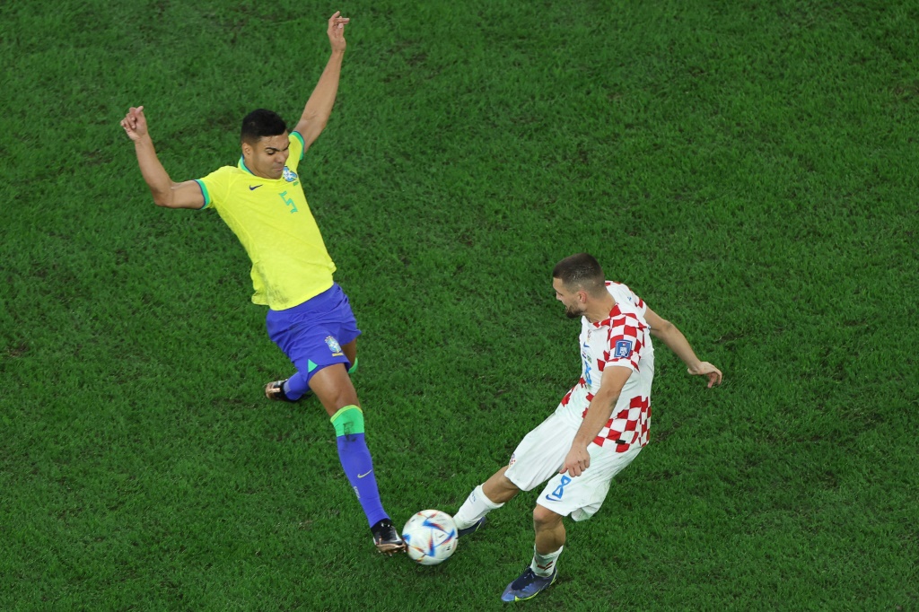 Le milieu de terrain brésilien Casemiro (g.) à la lutte pour le ballon avec le milieu de terrain croate Mateo Kovacic (d.) lors du quart de finale de la Coupe du monde 2022 entre la Croatie et le Brésil, à Al-Rayyan, à l'ouest de Doha, le 9 décembre 2022