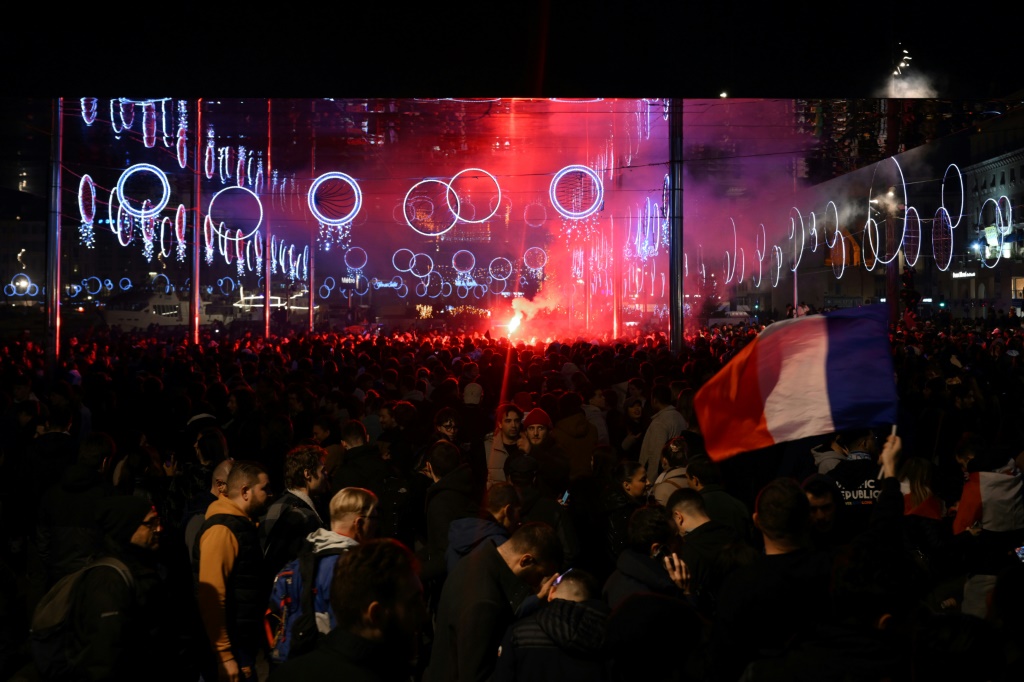 Des supporters célèbrent la victoire de la France contre le Maroc en demi-finale du Mondial-2022 de football, le 14 décembre 2022 à Marseille