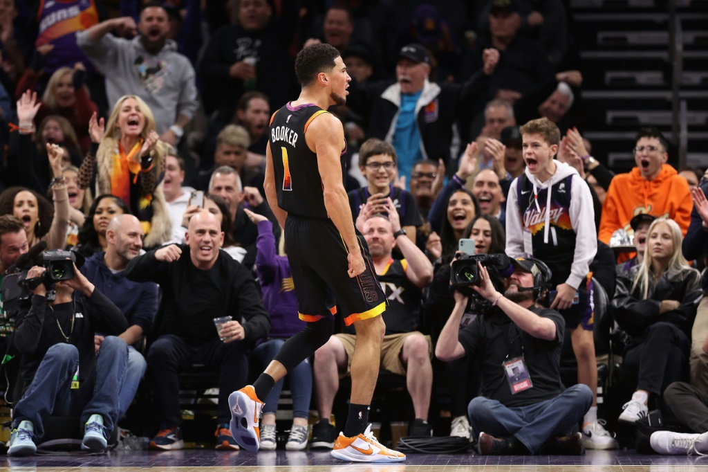 Devin Booker et des fans des Suns exultent après un panier inscrit par le joueur, lors d'un match de NBA contre la Nouvelle-Orléans, le 17 décembre 2022 à Phoenix
