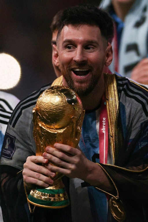 Le joueur et capitaine de l'équipe d'Argentine Lionel Messi tenant la Coupe du monde de football après la victoire de l'Argentine aux tirs aux buts face à la France le 18 décembre 2022 au stade Lusail à Qatar