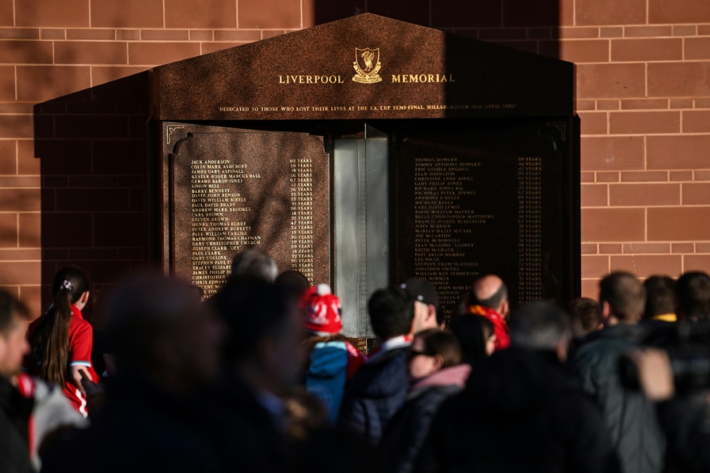 Des supporters de Liverpool se recueillent le 15 avril 2022 à Anfield devant la flame éternelle du Mémorial dédié aux victimes du drame de Hillsborough