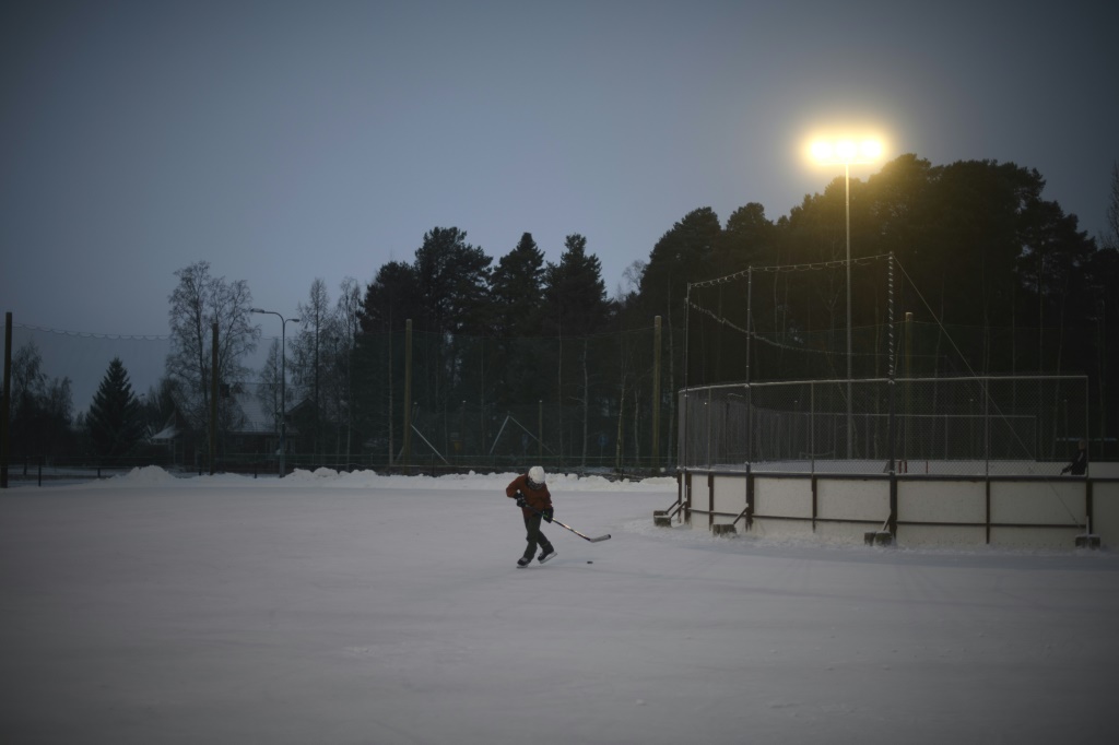 Un enfant de l'équipe Ahmas attend le début de l'entraînement de hockey sur glace sur la patinoire extérieure de Pateniemi, près d'Oulu, le 1er décembre 2022.