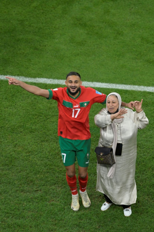 Sofiane Boufal danse avec sa mère après la qualification du Maroc pour les demi-finales de la Coupe du monde le 10 décembre 2022 sur la la pelouse du stade Al-Thumama de Doha
