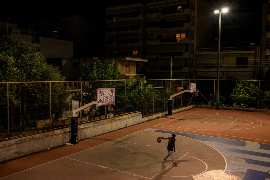 Le jeune Prince Kuworde s'entraîne sous les lumières du terrain de basket à Athènes, le 16 octobre 2022