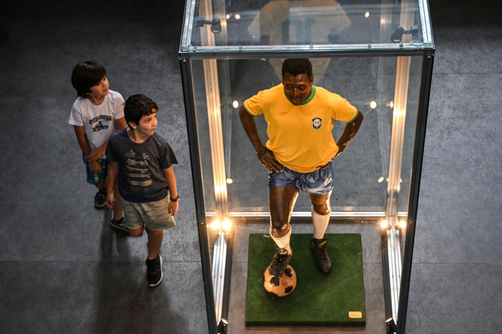 Deux enfants regardent une statue de Pelé dans le musée qui lui est consacré à Santos, le 27 décembre 2022