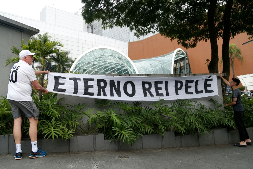 Des fans de la légende du football brésilien Pelé accrochent une bannière sur laquelle on peut lire Eternal King Pele devant l'hôpital israélite Albert Einstein, où Pelé est décédé après une longue bataille contre le cancer, à Sao Paulo, au Brésil, le 29 décembre 2022