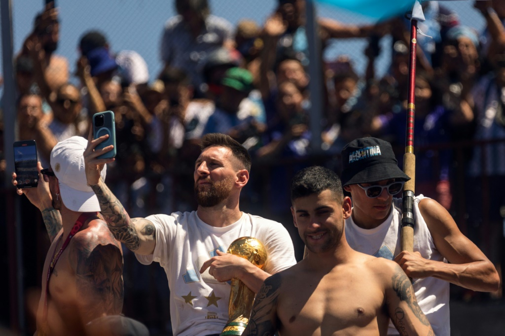 Lionel Messi prend un selfie avec la coupe du monde lors des célébrations de la sélection argentine à Buenos Aires