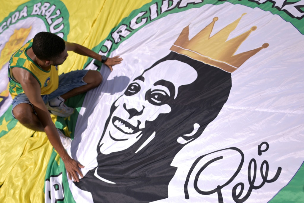 Un admirateur de Pelé rend hommage à la légende brésilienne du football devant une réplique de la maison où le footballeur est né à Tres Coracoes (Brésil)