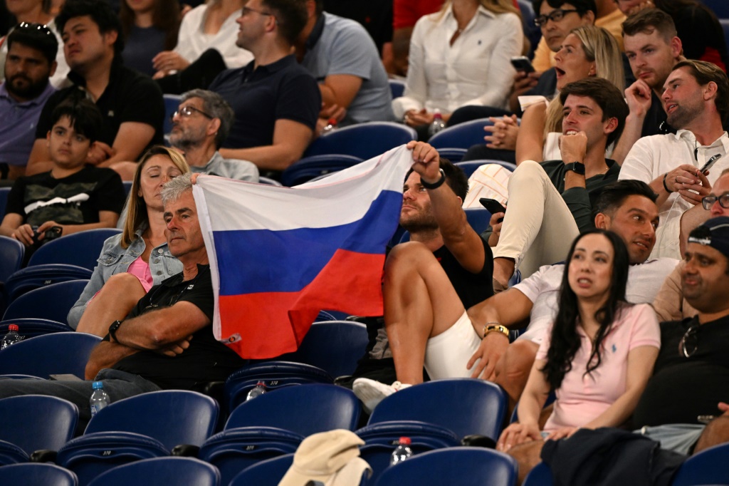 Un supporter déploie un drapeau russe à l'Open d'Australie pendant un match entre l'Américain Marcos Giron et le Russe Daniil Medvedev