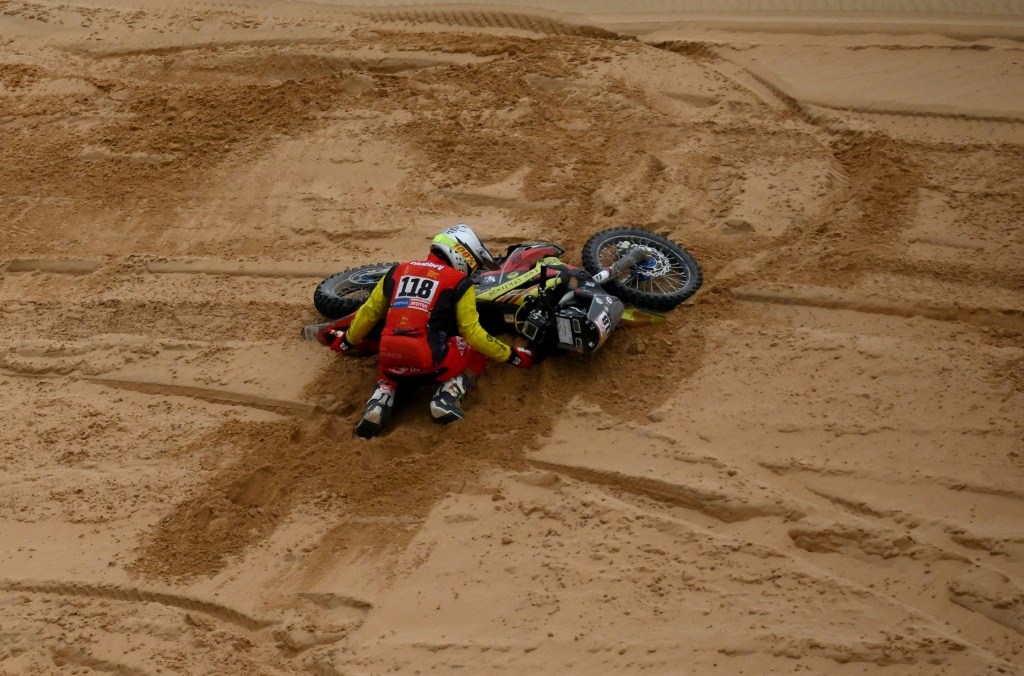 Le Français Benjamin Lepelley tente de relever sa moto après une chute lors de la 8e étape du Dakar, entre Al-Duwadimi et Ryad, le 8 janvier 2023