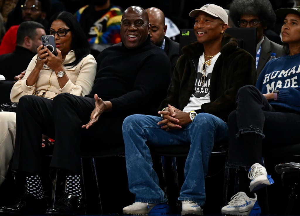 L'ancienne star de la NBA Magic Johnson (c) et le chanteur et producteur Pharell Williams assistent au match de NBA entre Détroit et Chicago, le 19 janvier 2023 à Bercy