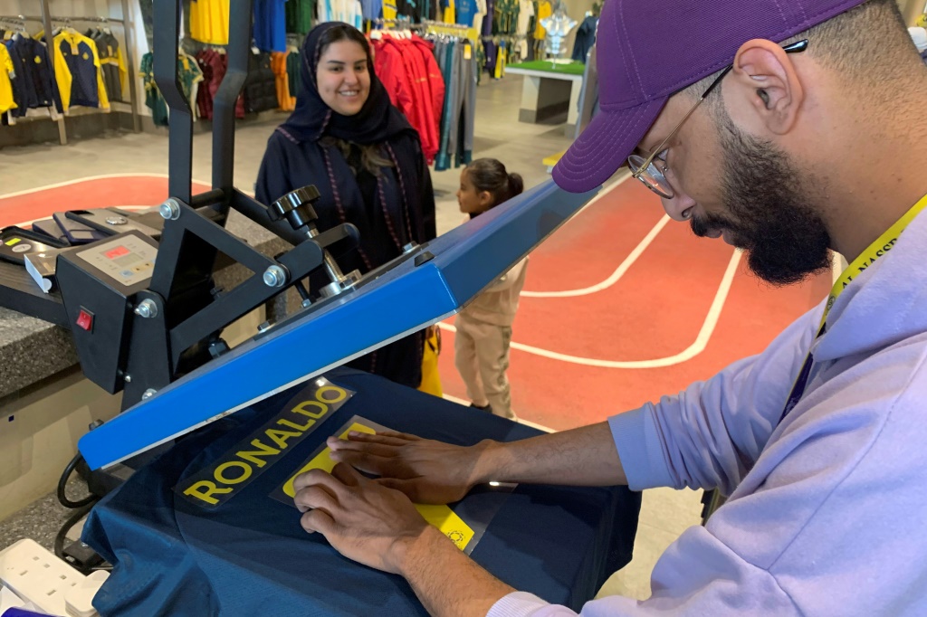 Un employé du club saoudien Al-Nassr prépare un maillot portant le nom de Ronaldo à Riyadh, le 31 décembre 2022