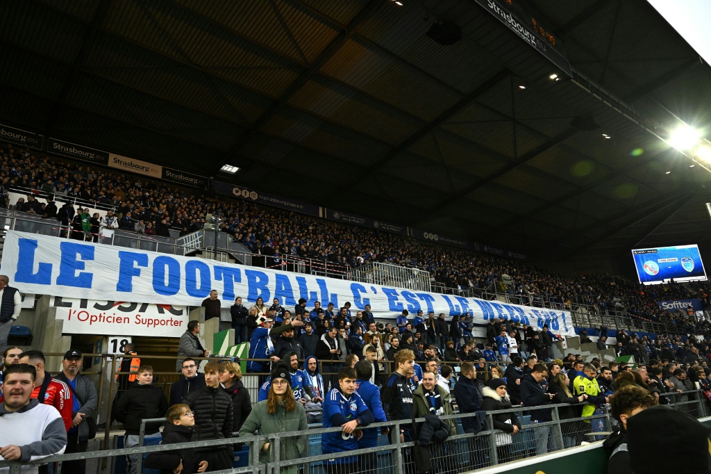 Les supporters du RC Strasbourg déploient une banderole: Le football, c'est le weekend, lors du match contre Troyes à la Meinau, le 2 janvier 2023