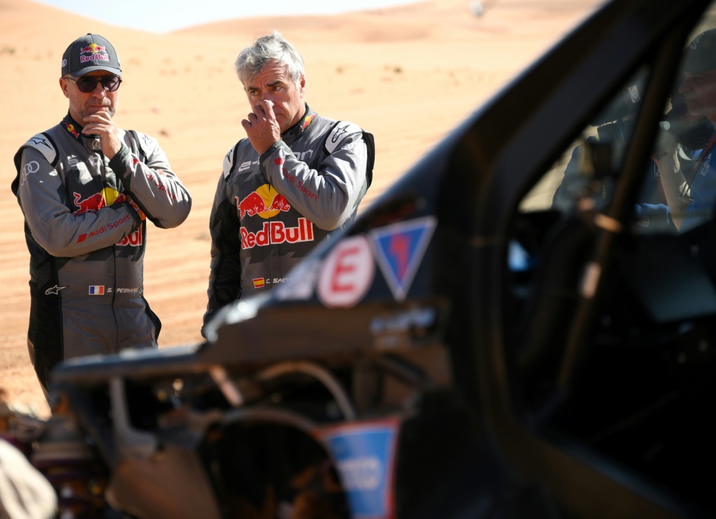 Le Français Stéphane Peterhansel (G) et l'Espagnol Carlos Sainz, les deux pilotes Audi hybride, ont été victimes d'un accident au même endroit lors le 6e étape du Dakar-2023 entre Haïl et Ryad, en Arabie saoudite, le 6 janvier 2023