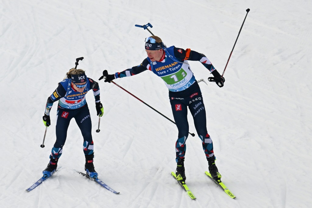 Le Norvégien Johannes Boe (D) passe le relais à Marte Olsbu Roeiseland lors du relais mixte simple des Mondiaux de biathlon à Oberhof (Allemagne) le 16 février 2023