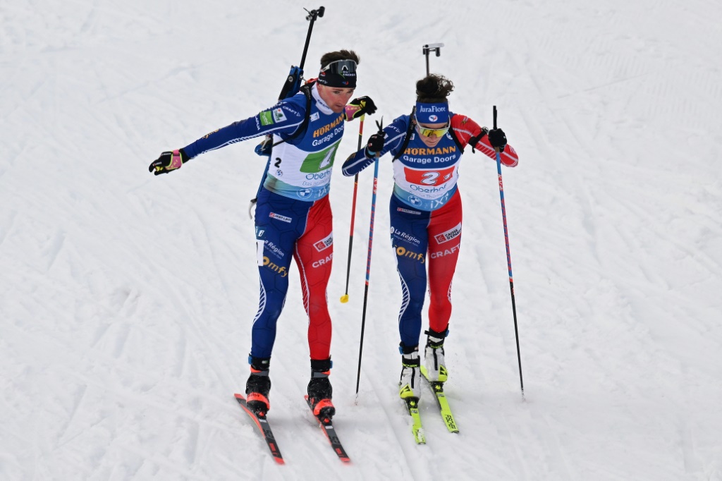 Le Français Fabien Claude (G) passe le relais à Lou Jeanmonnot lors du relais mixte simple des Mondiaux de biathlon à Oberhof (Allemagne) le 16 février 2023