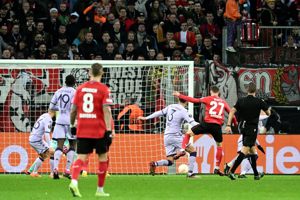 Le joueur du club allemand du Bayer Leverkusen Florian Wirtz (N.27) marque le 2e but de son équipe lors de la défaite 3-2 contre le club français de Monaco lors du match de barrage aller de la Ligue Europa au stade de Leverkusen le 16 février 2023.