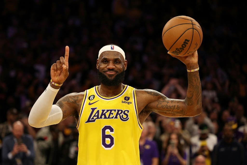 La légende des LA Lakers LeBron James avec le ballon de meilleur marqueur de l'histoire de la NBA tout juste remis par Kareem Abdul-Jabbar, le 7 février 2023 à Los Angeles
