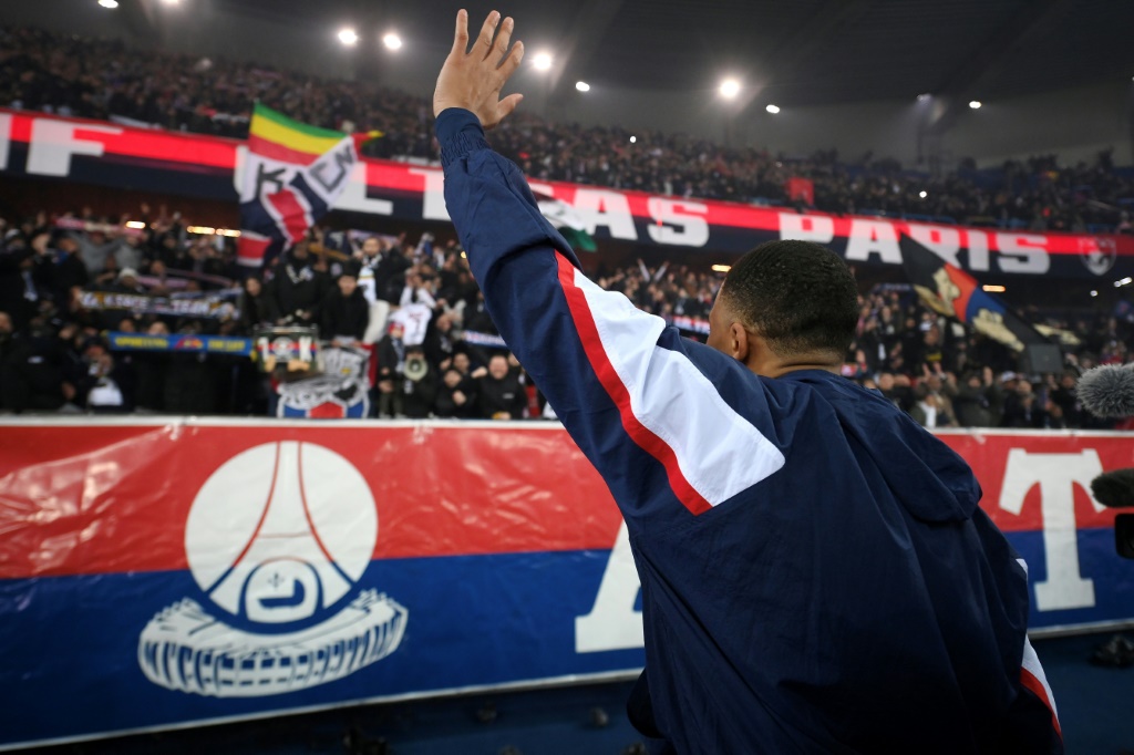 La star française du Paris SG Kylian Mbappe salue les ultras du club parisien après avoir battu le record de buts lors du match de Ligue 1 contre le FC Nantes, le 4 mars 2023