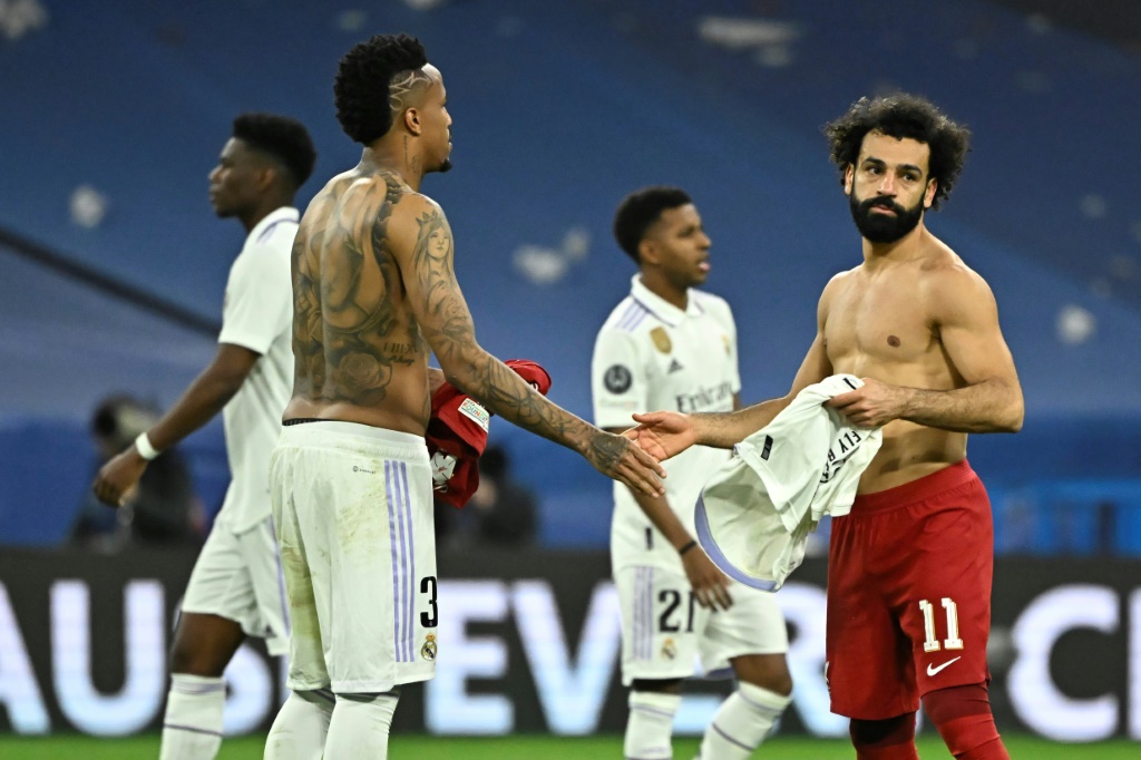Echange de maillots entre le défenseur du Real Eder Militao (g) et l'attaquant de Liverpool Mohamed Salag à la fin de leur 8e de finale retour de Ligue des champions, le 15 mars 2023 à Madrid