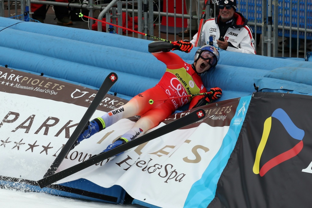 Le Suisse Marco Odermatt célèbre son triomphe dans le géant des finales de la Coupe du monde de ski alpin en se jetant dans les protections de l'air d'arrivée, samedi 16 mars 2023 à Soldeu (Andorre)