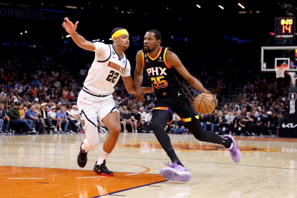 Kevin Durant (d.), l'ailier fort des Phoenix Suns, tente de passer Zeke Nnaji (g.), le pivot des Denver Nuggets, pendant un ma&tch NBA à Phoenix, le 6 avril 2023