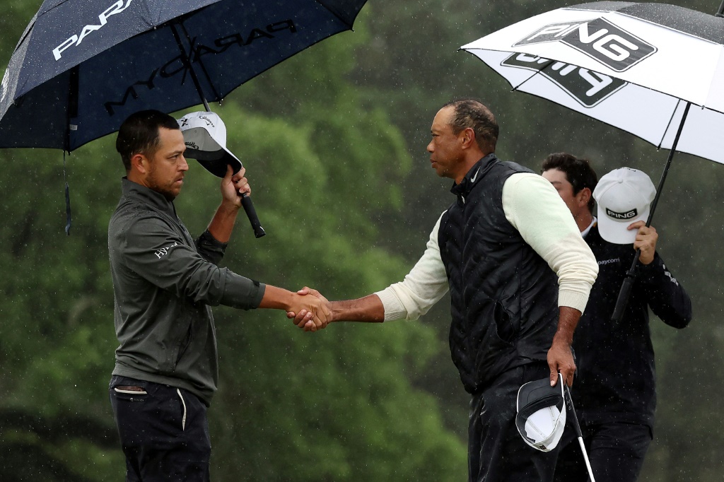 Poignée de mains entre Tiger Woods (à droite) et Xander Schauffele avant la reprise du 2e Tour au Masters d'Augusta, le 8 avril 2023