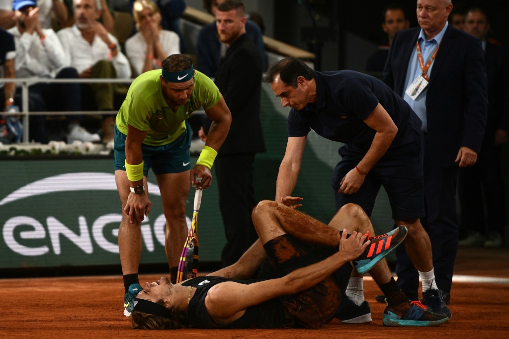 Rafael Nadal au chevet d'Alexander Zverev le 3 juin 2022 en demi-finale du tournoi de Roland-Garros. L'Allemand, victime d'un arrachement des ligaments de la cheville droite, a été contraint à l'abandon alors que le score était de 7-6 (10/8), 6-6 en faveur de l'Espagnol