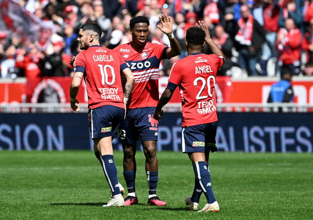 L'attaquant canadien Jonathan David (c) félicité par Rémy Cabella (g) et Angel Gomes après son but pour Lille face à Montpellier, le 16 avril 2023 au stade Pierre-Mauroy