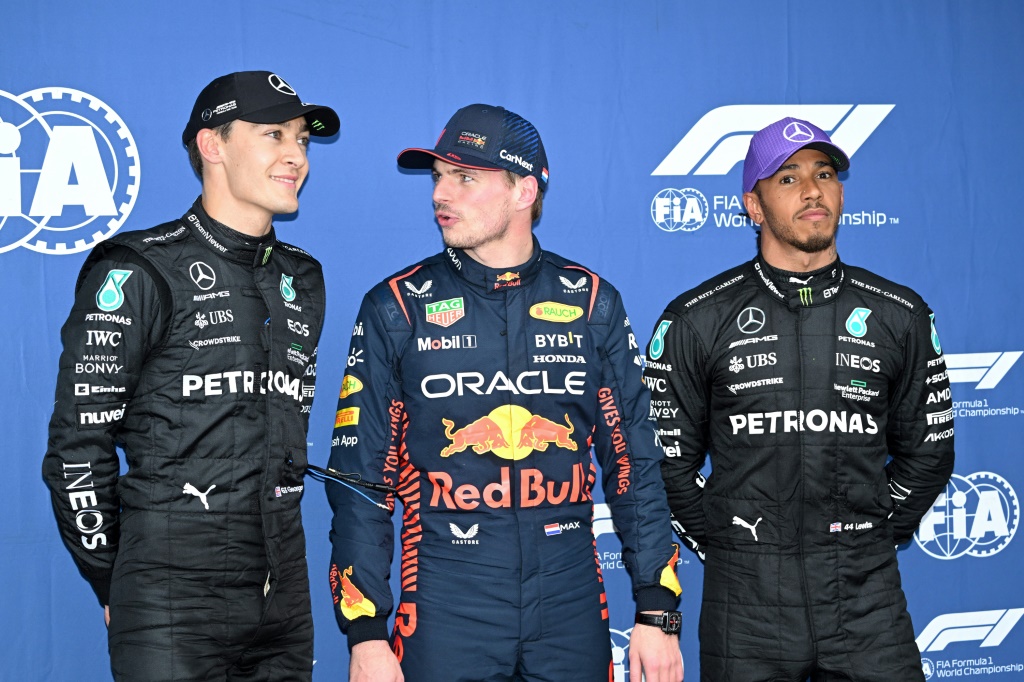 Le pilote néerlandais de Red Bull Max Verstappen (c.), qui a obtenu la pole position, pose avec les pilotes britanniques de Mercedes George Russell (g.) et Lewis Hamilton (d.), après la séance de qualification du Grand Prix d'Australie de F1, à Melbourne, le 1er avril 2023