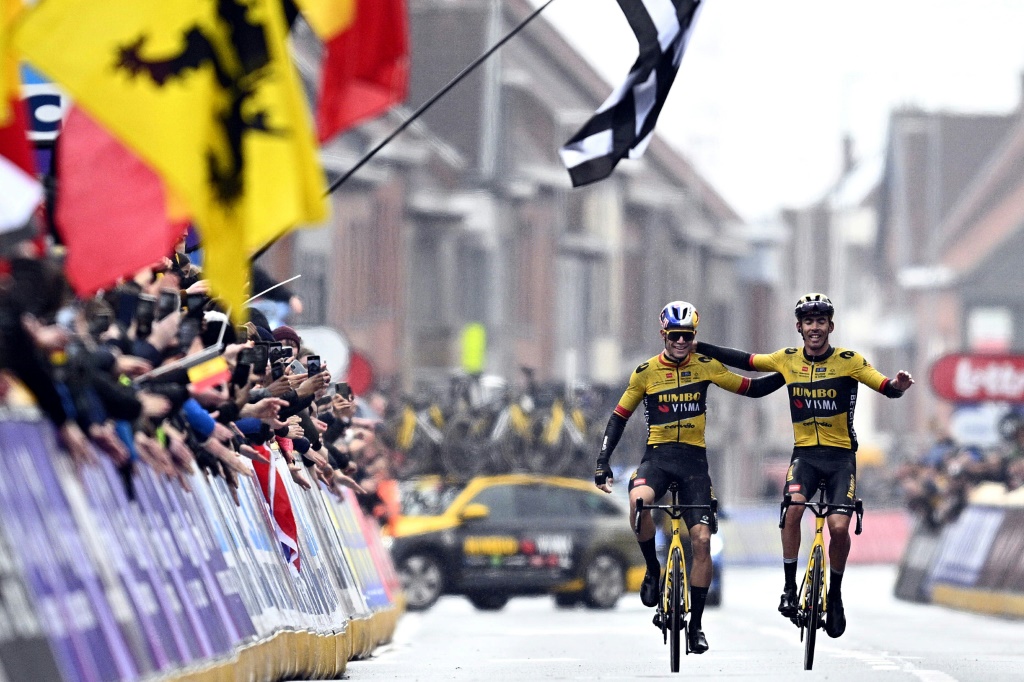 Le Belge Wout van Aert et le Français Christophe Laporte de la Jumbo-Visma bras dessus, bras dessous, après la course cycliste A travers la Flandre le 29 mars 2023 à Waregem en Belgique