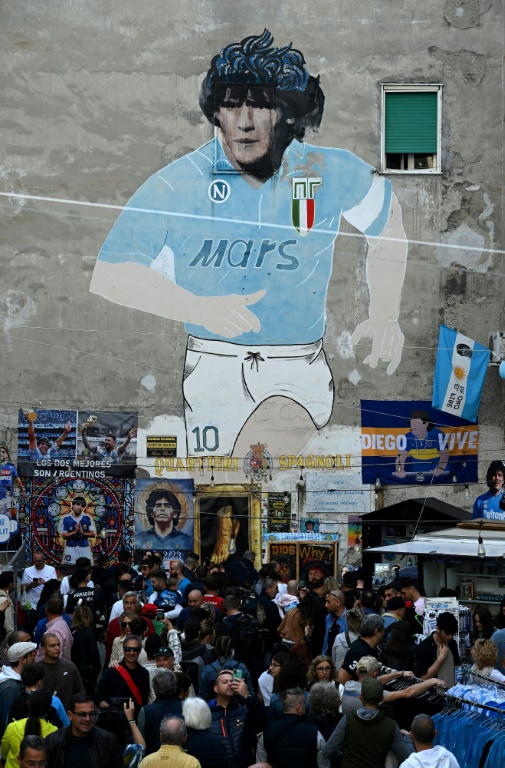 Des supporters napolitains défilent devant une fresque dédiée à Diego Maradona. L'Argentin, toujours une idole à Naples, avait mené le club à ses titres de champion d'Italie en 1987 et 1990.